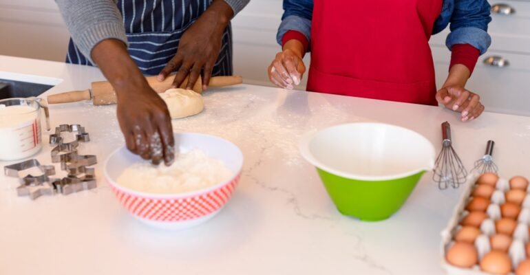 midsection-african-american-couple-wearing-aprons-baking-together-min